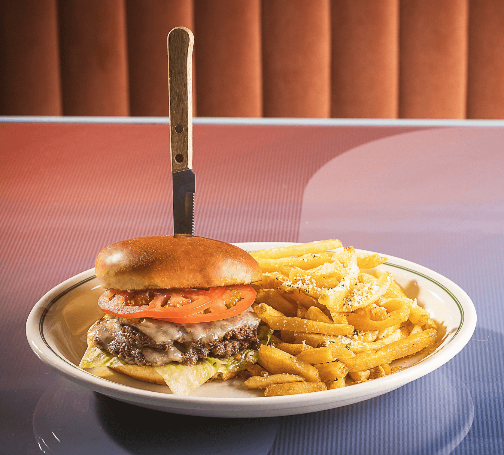 F Sixteen Class American Diner featuring Beef Burger with lettuce tomato, and secret sauce with a side of garlic seasoned fries 2